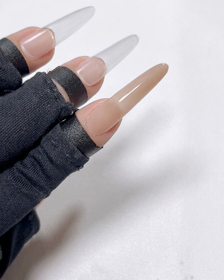 The index finger nail showing a reflective metallic golden mirror powder finish.