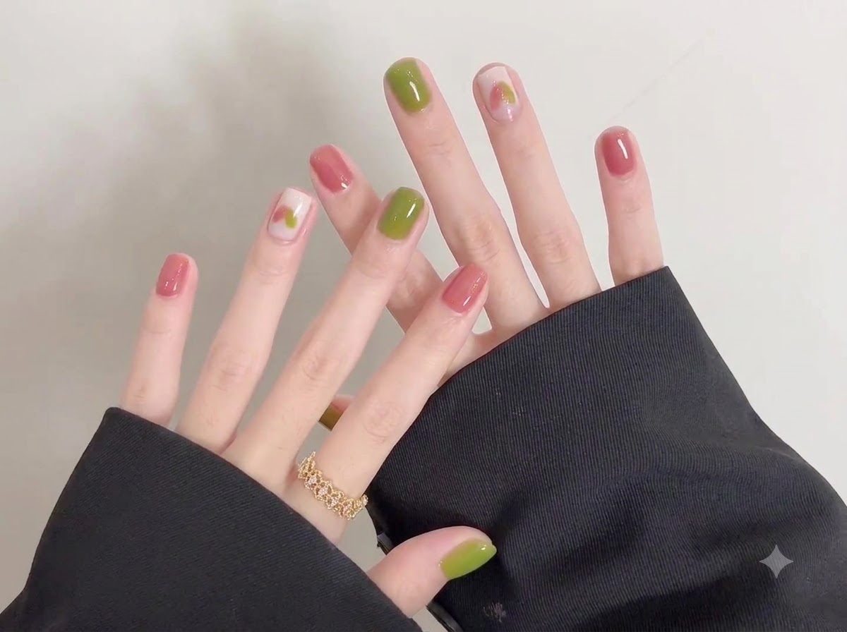 A detailed view of the left hand fingers adorned with a gold ring alongside the freshly polished gel nails.