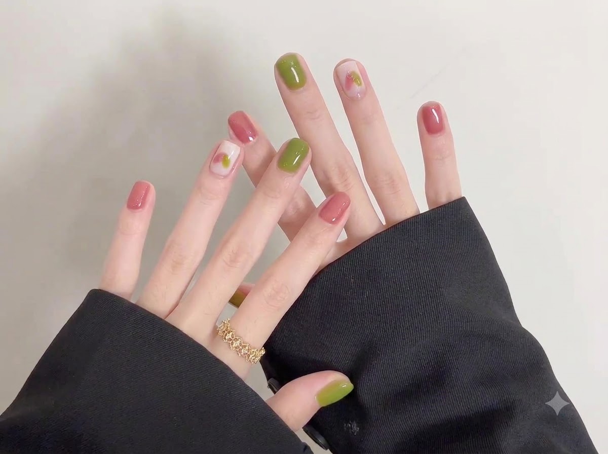 A close-up shot highlighting intricate doodle artwork created over a soft, light base coat on short nails.