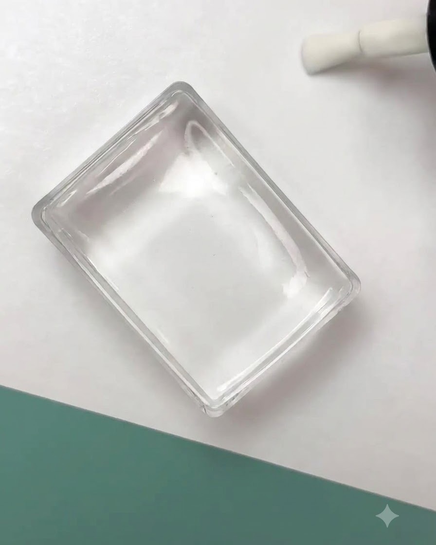 A clear silicone stamper pressing a black floral outline design onto a prepared nail surface.
