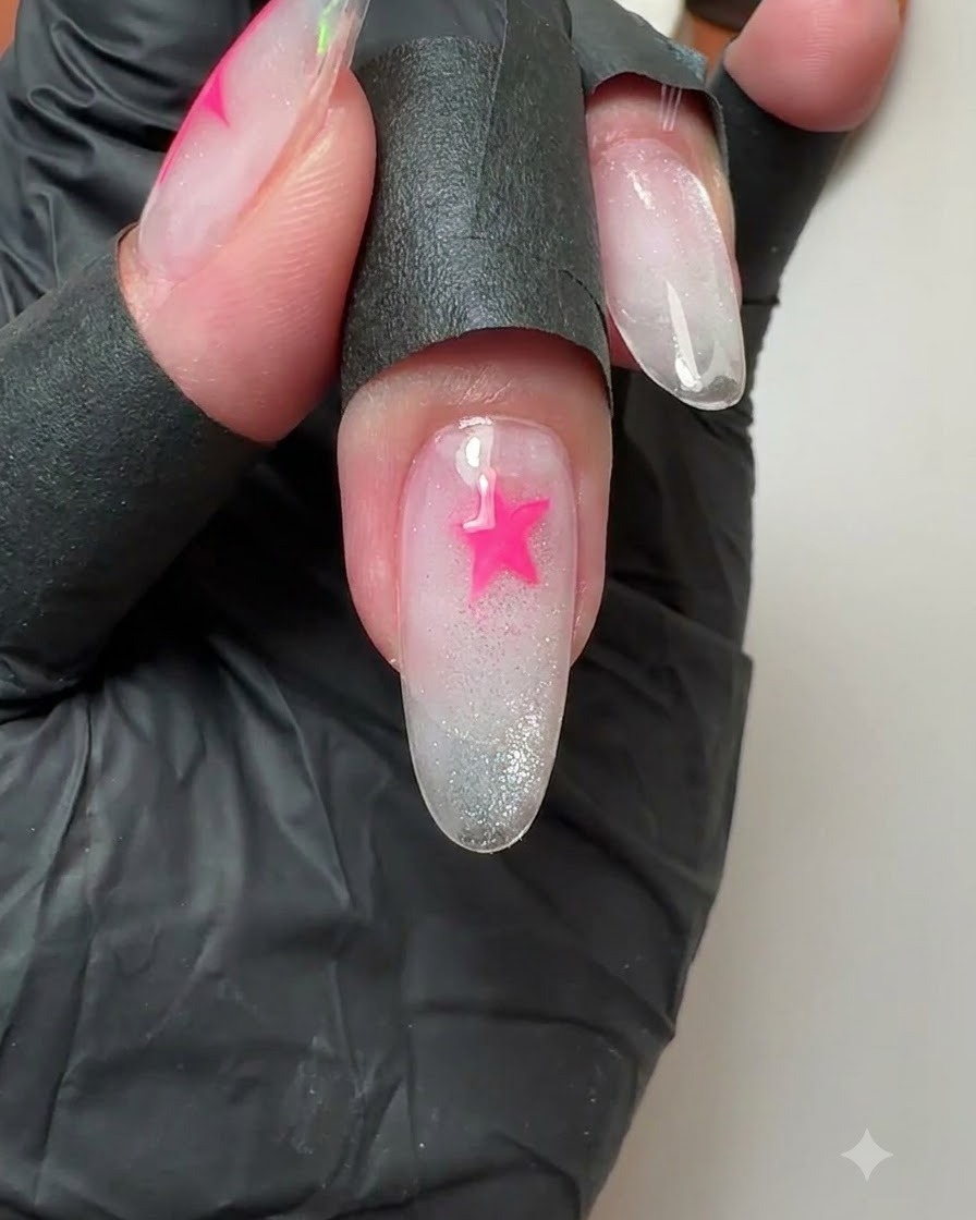 A close-up of a middle fingernail showing a freshly painted vibrant pink star.