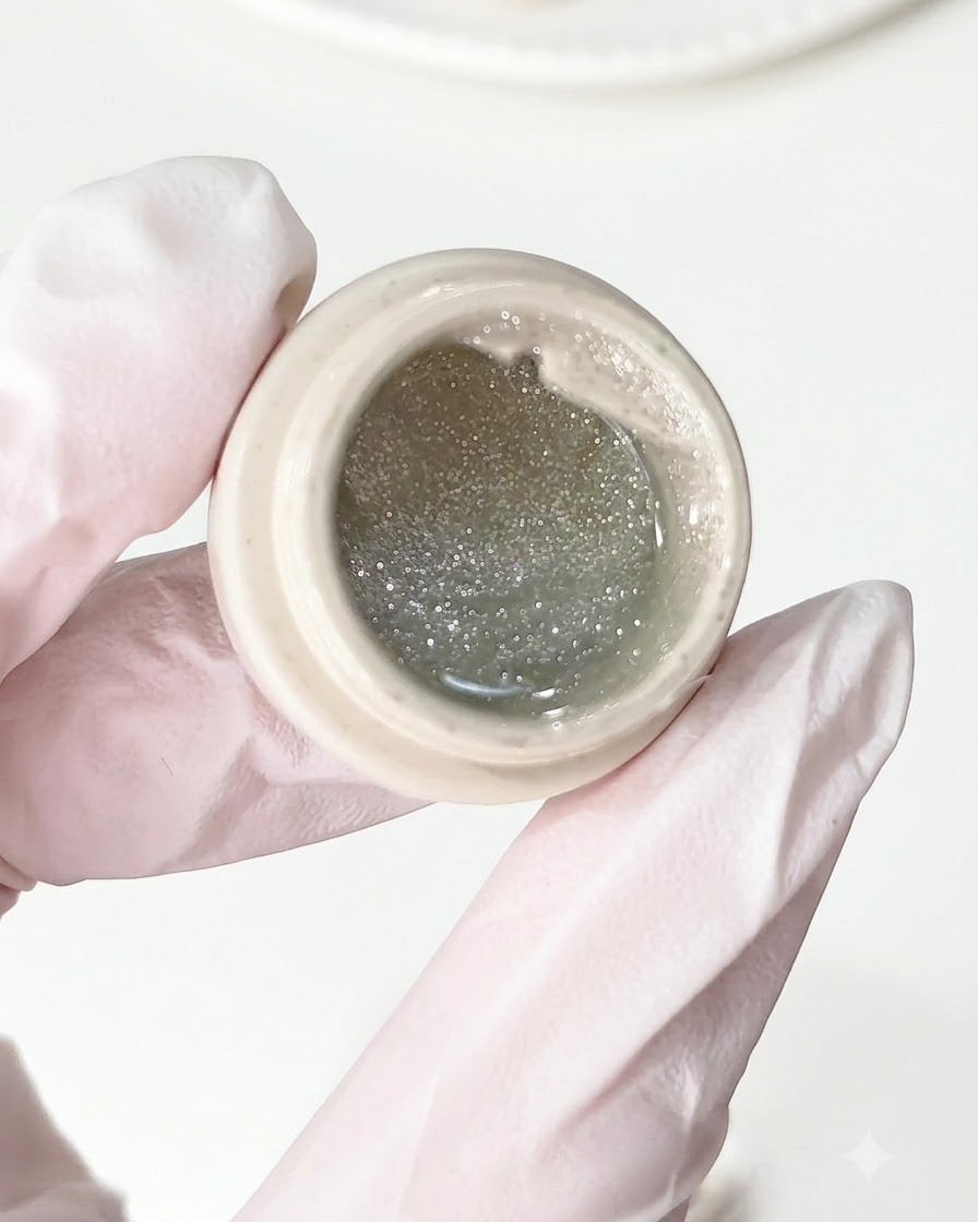 A brush applying crushed diamond gel onto a prepped nail base.