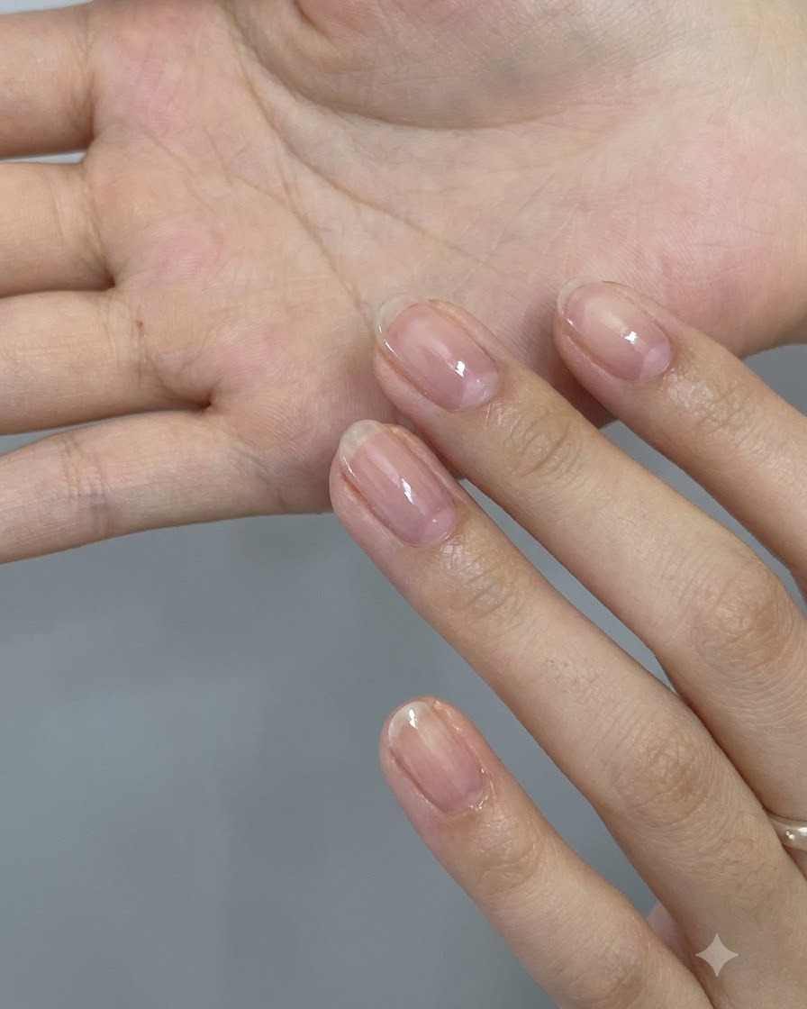 A close-up view of a hand holding an assortment of holographic pink star and heart-shaped glitter flakes on the palm.
