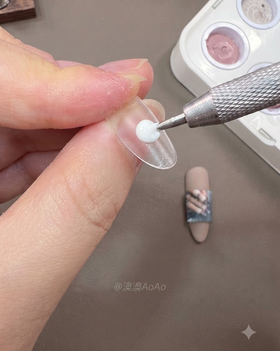 Three clear false nail tips mounted on temporary stands with guide strips attached on a clean workspace.