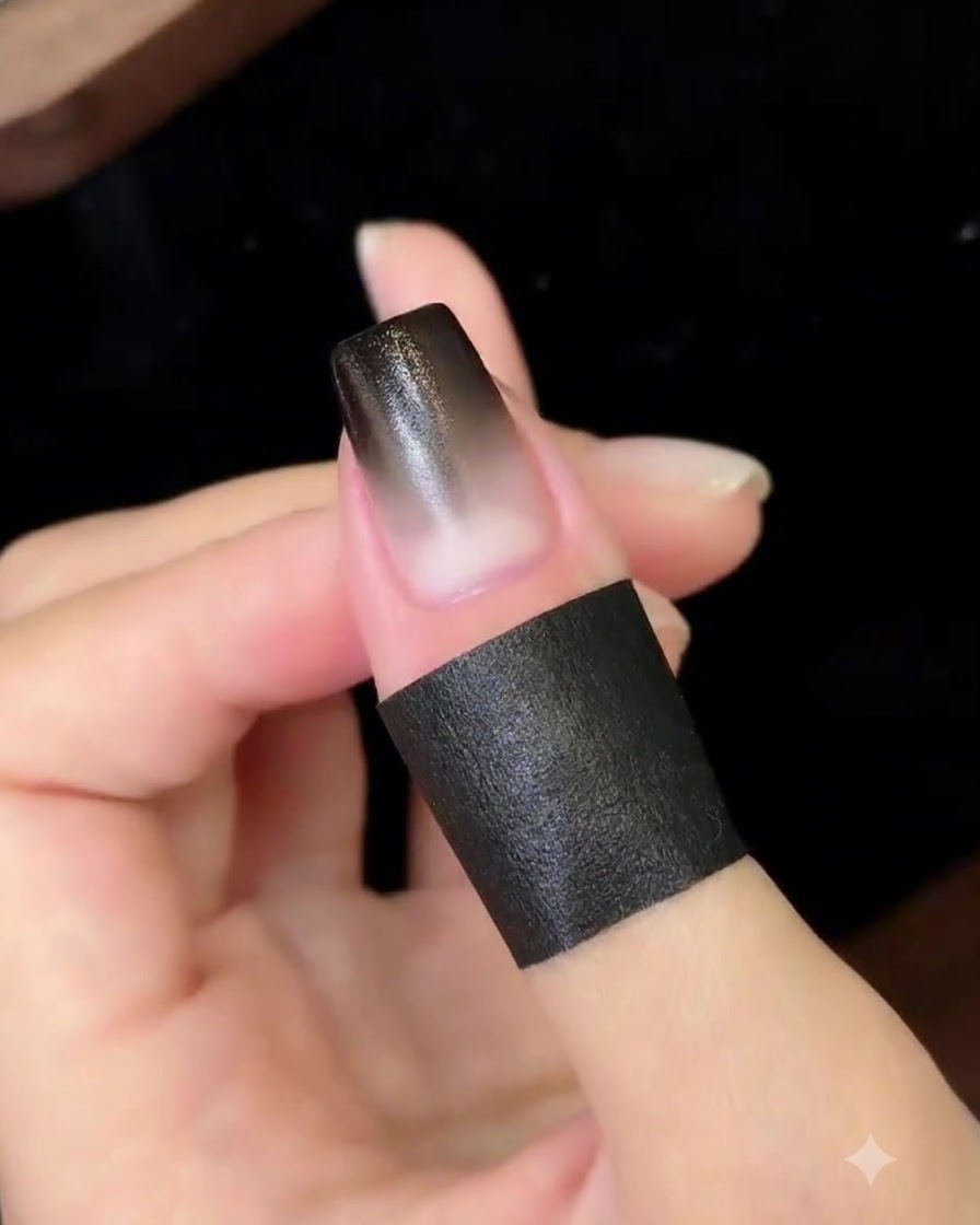 A finished gradient nail curing under a compact UV/LED nail lamp.