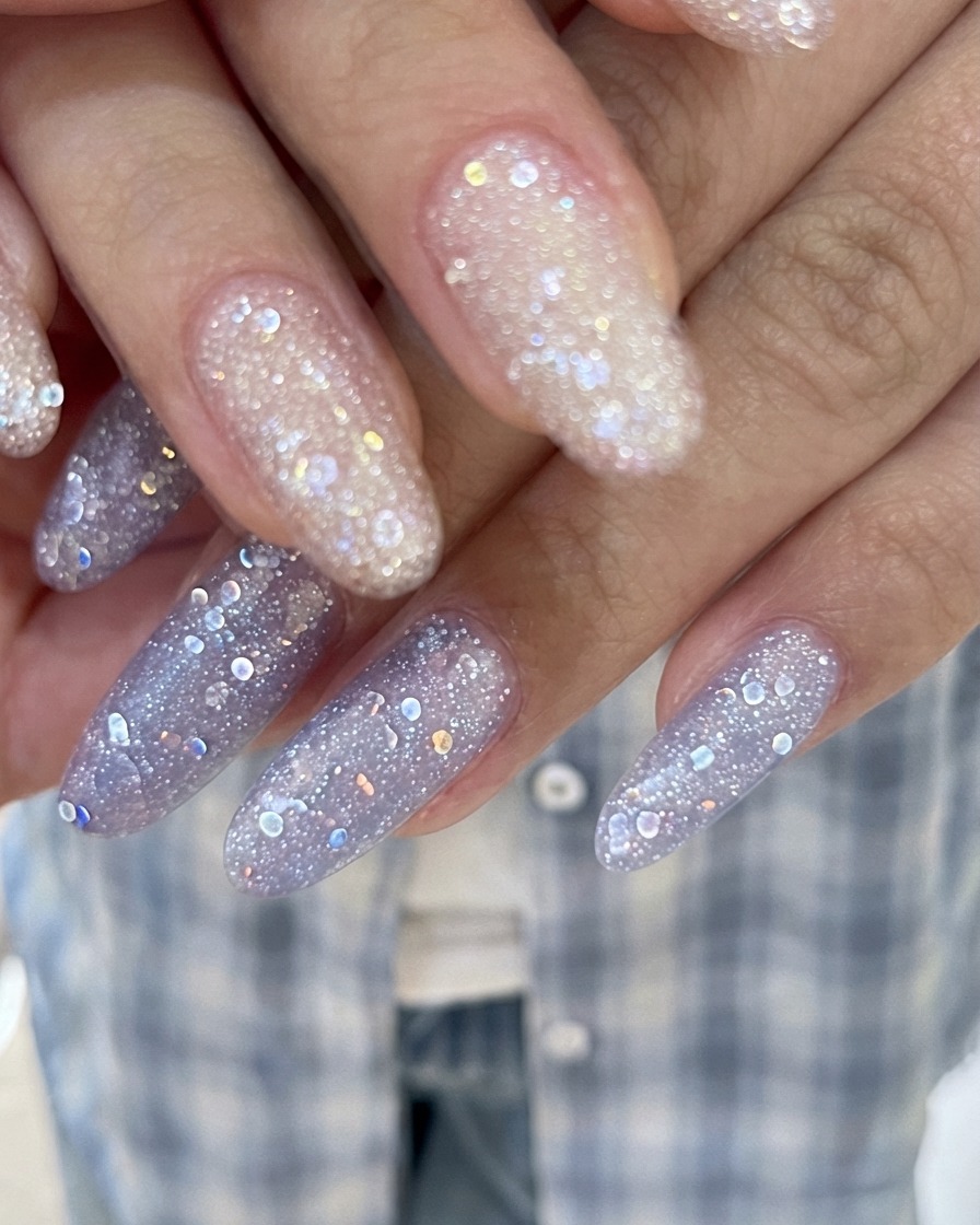 An angled macro view focusing on the sparkling texture of glossy glitter gel manicured nails.
