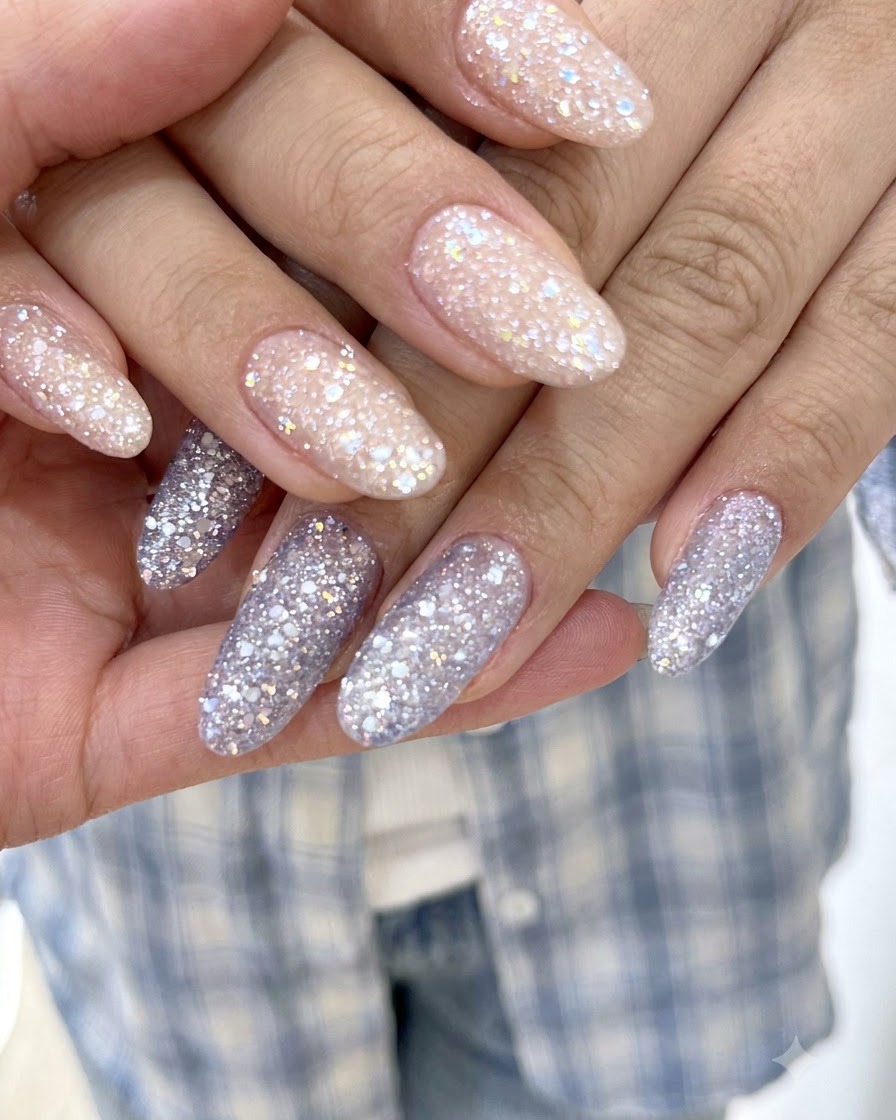 A sharp macro view highlighting fine sparkling particles on lavender-purple glitter gel nails.