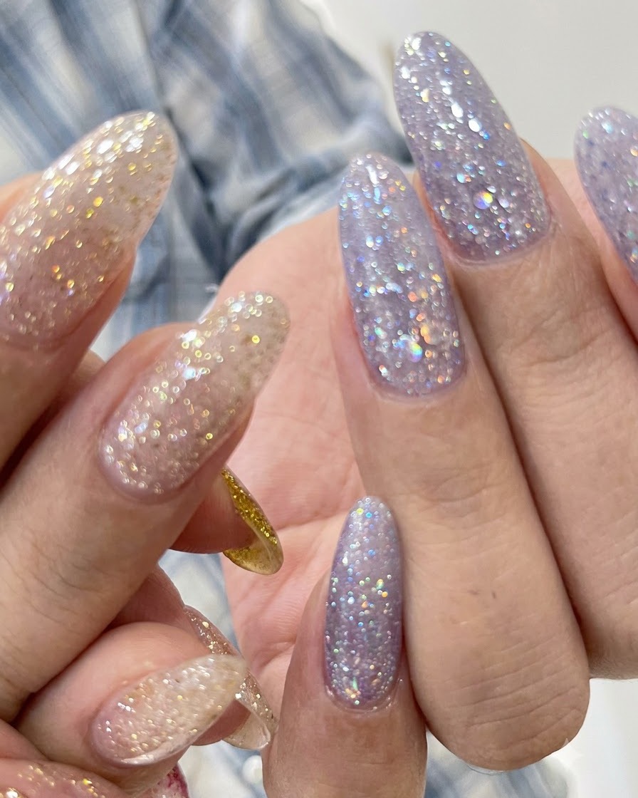 A close-up view of purple glitter textured nails with a neat cuticle line.