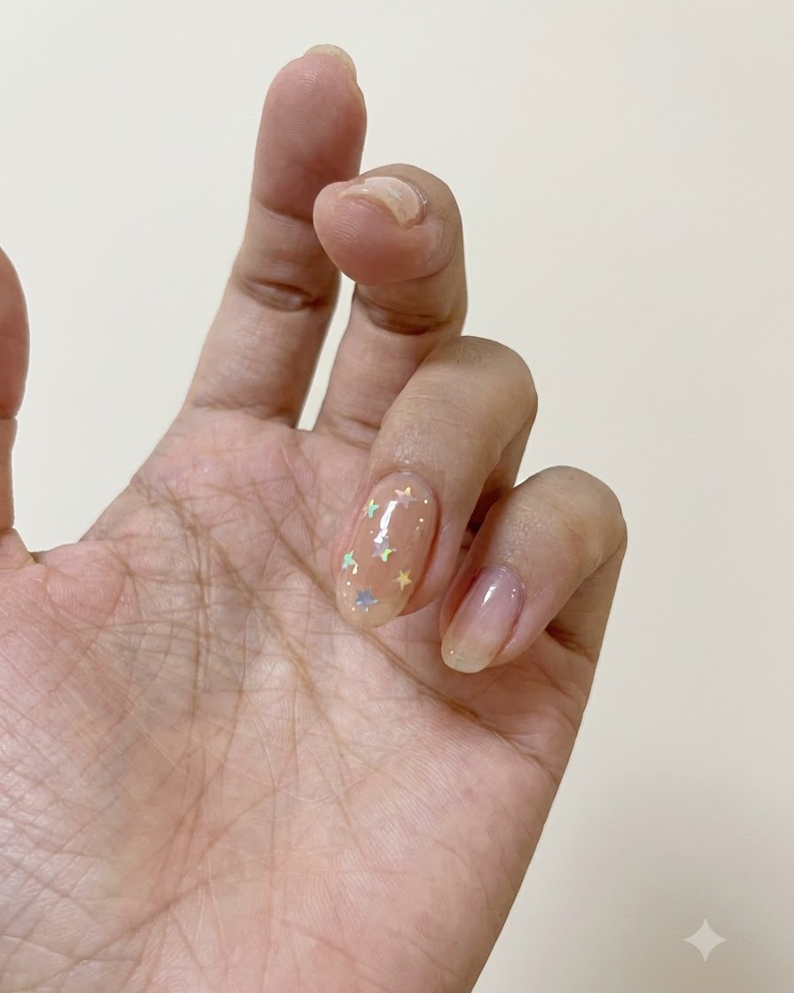 A nail brush applying matte top coat over a nail decorated with polarized stars.