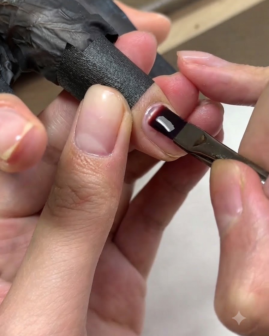 A brush applying a secondary layer of gel over the nail plate to perfect the structure.
