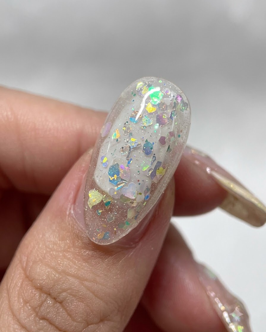 A close-up of a finger holding a clear nail tip upside down to let the gel self-level smoothly.