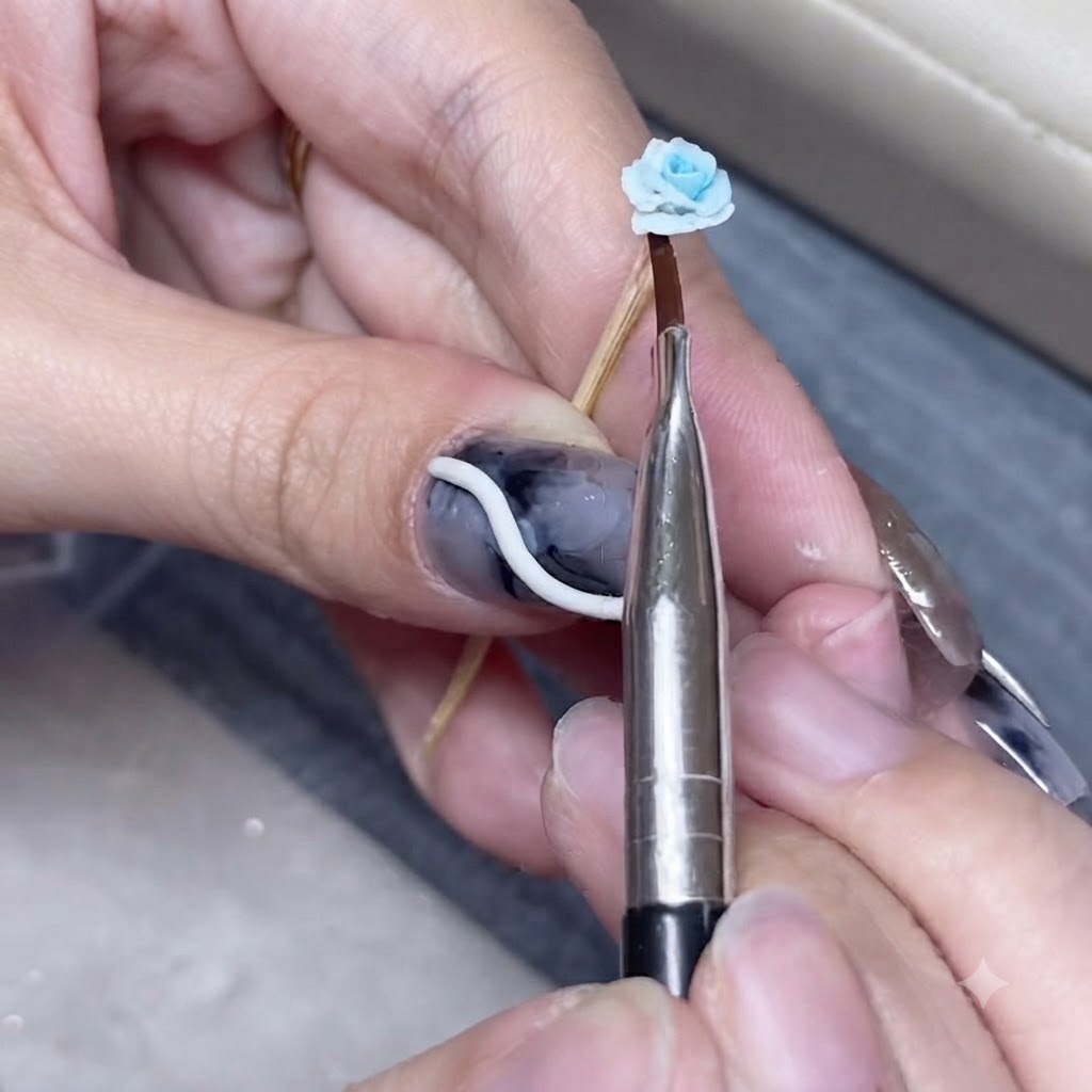 A pointed metal tool pressing delicate ruffles into the edge of a blue clay rose.
