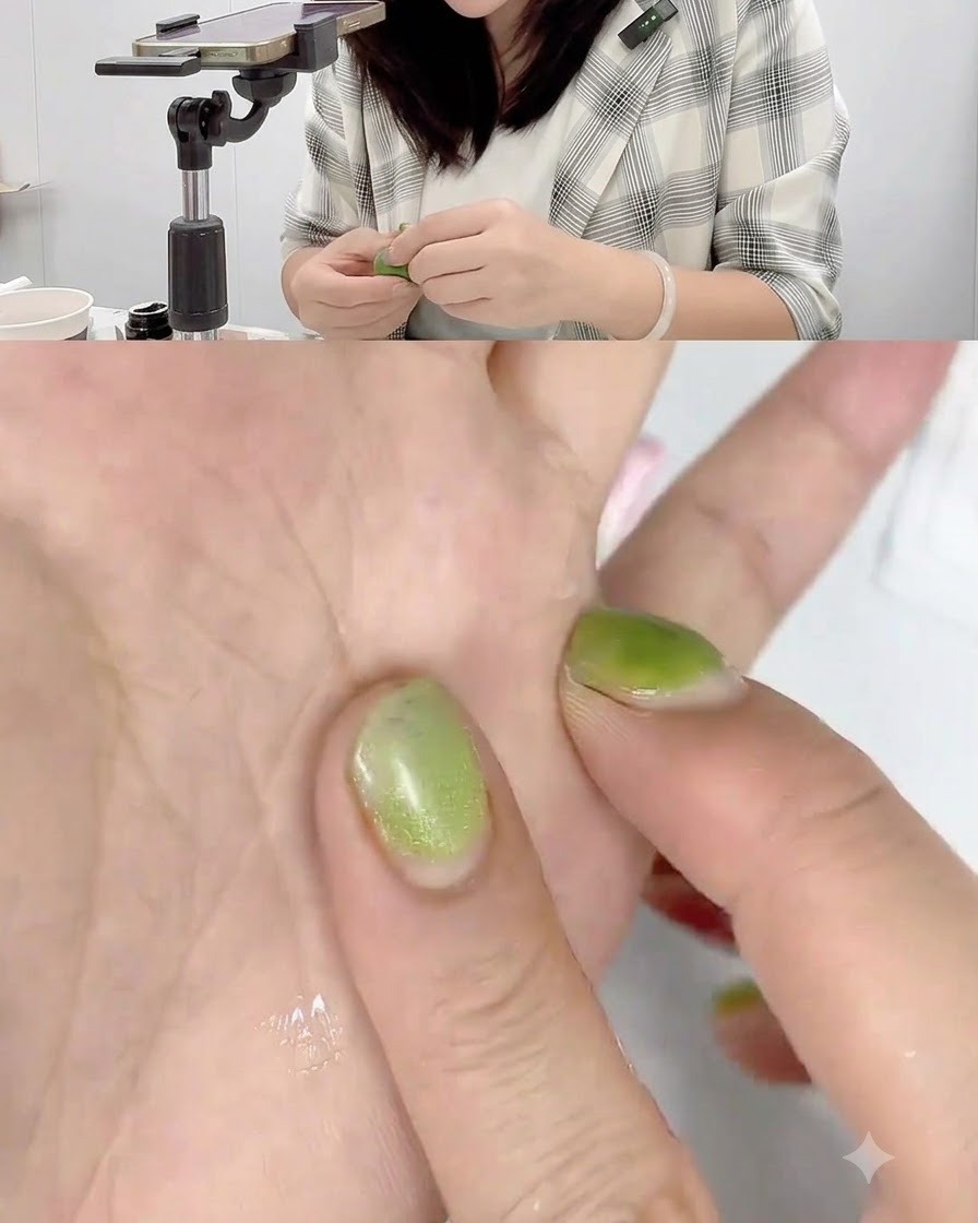 A hand pressing a small ball of pink sculpting gel flat against the palm to form a thin disc shape.