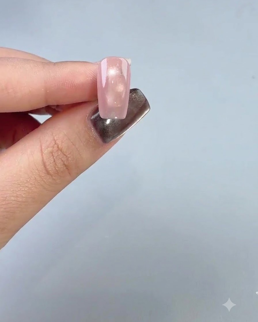 A manicured finger displaying a smooth base coat applied to the fourth nail.