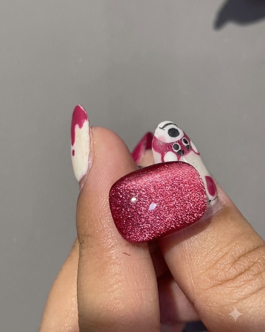 A close-up shot of a magnet fine-tuning the lower reflection on a red cat eye gel nail surface.