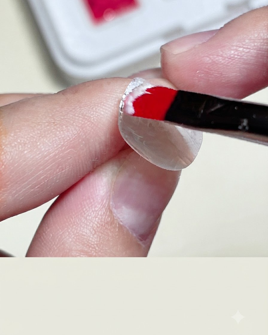 A close-up of a hand applying clear tape strips onto a white nail base to create a bordered square area.