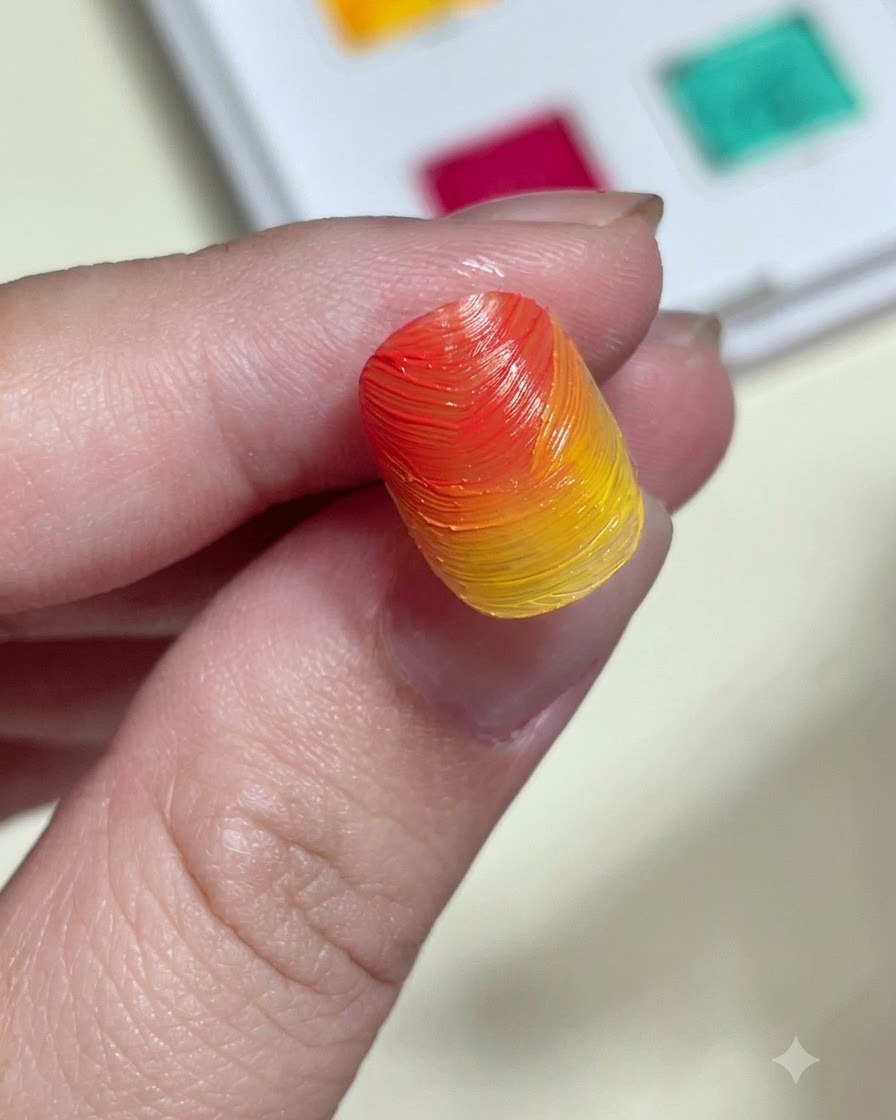 A sponge applicator rubbing shimmering aurora powder onto a textured orange and yellow gradient nail tip.