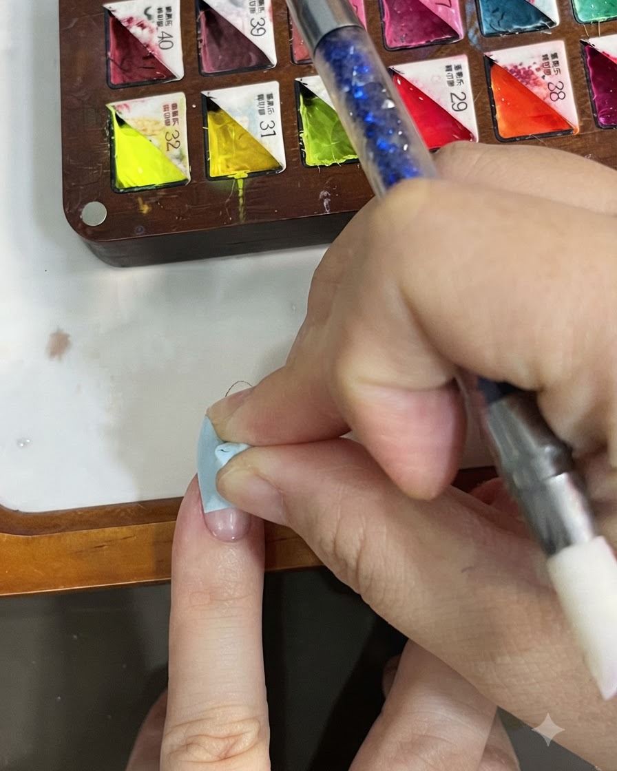 A finger holding a cleanser wipe cleaning the surface of a cured nail.