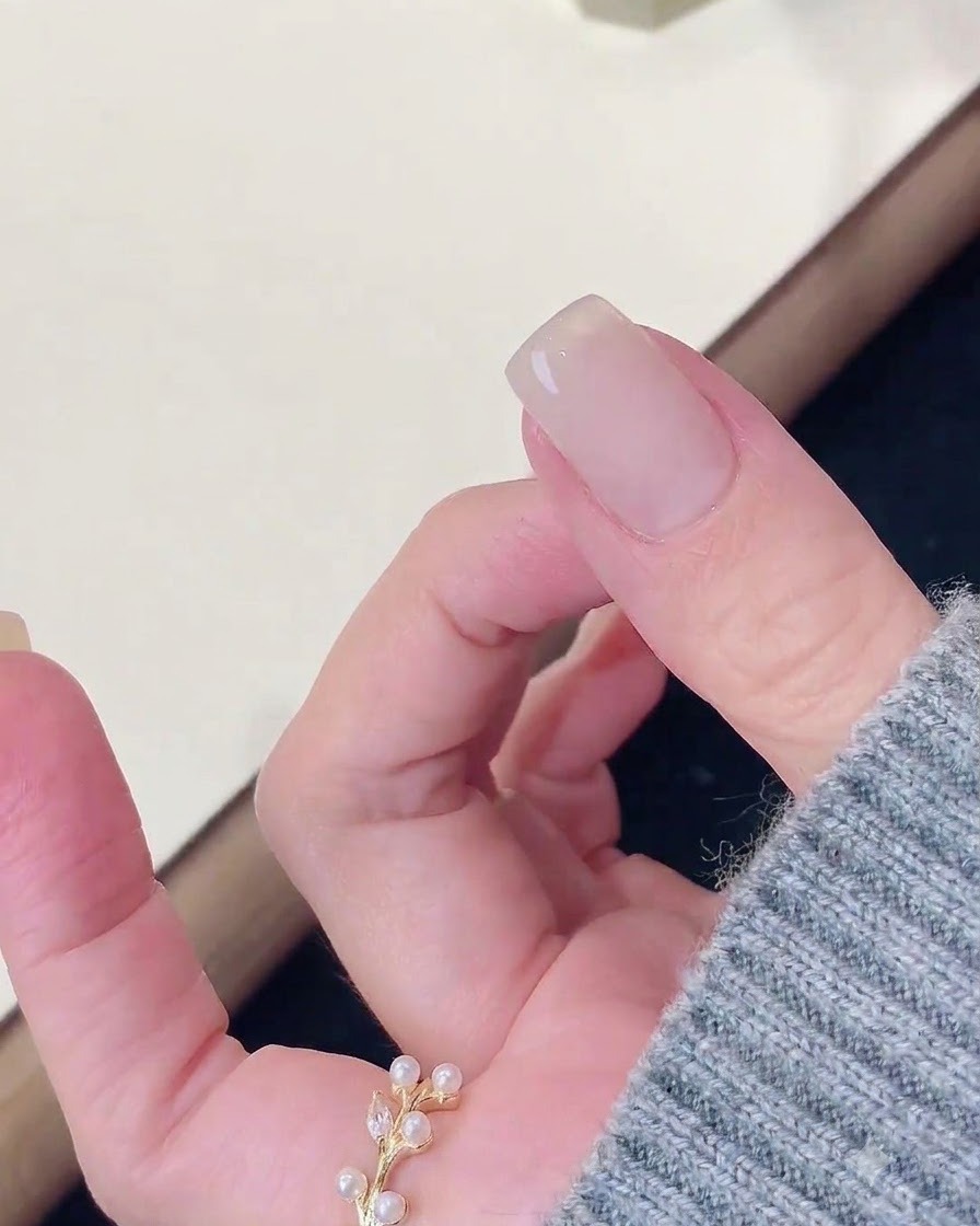 A finger resting after being cured under a nail lamp, with a wipe cleaning the surface.