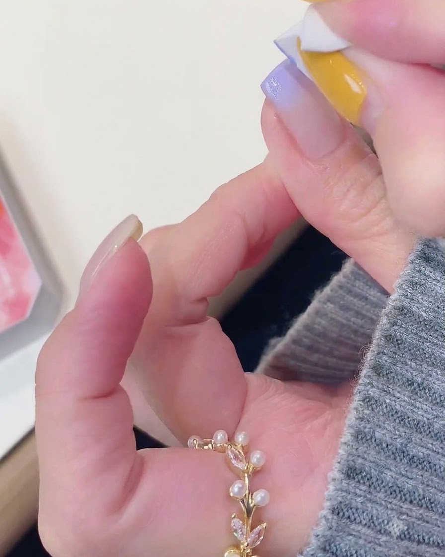 A sponge tool softly dabbing purple gel onto the tip of a manicured nail.