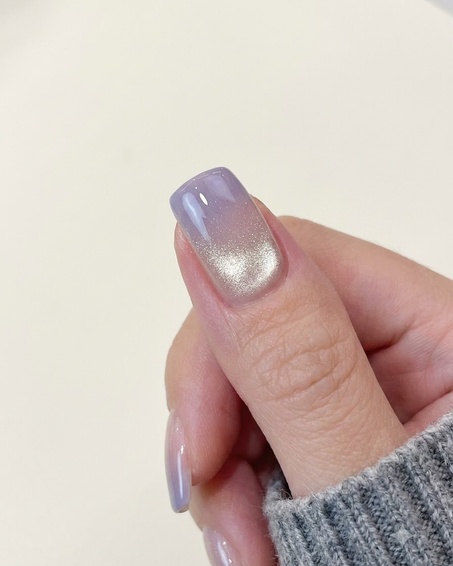 A completed purple gradient cat-eye nail showing a bright shimmering light band near the back edge.