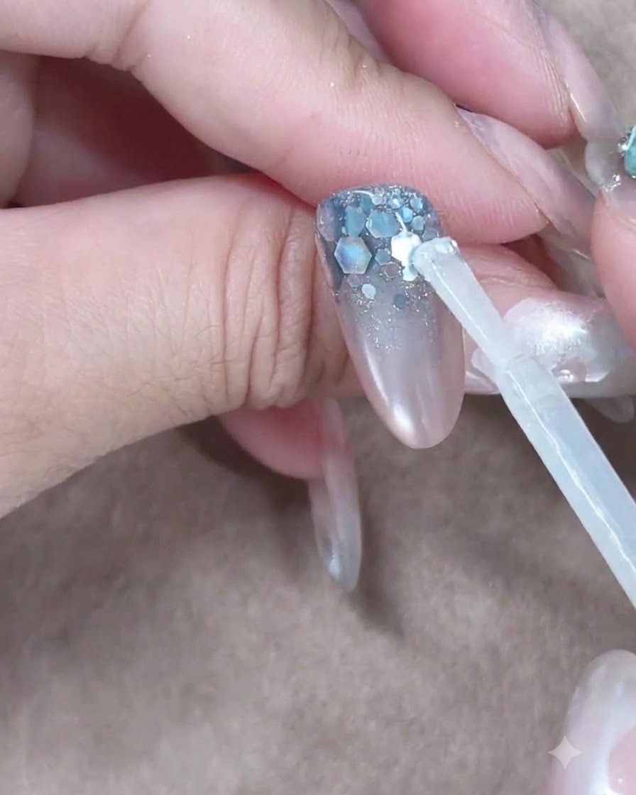 A builder gel brush placing a clear bead near the cuticle to float down the nail.