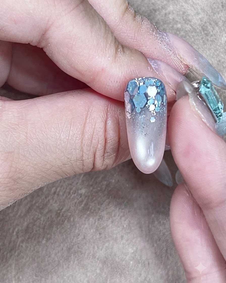 A completed nail structure with self-leveled clear builder gel encasing the glitter art.