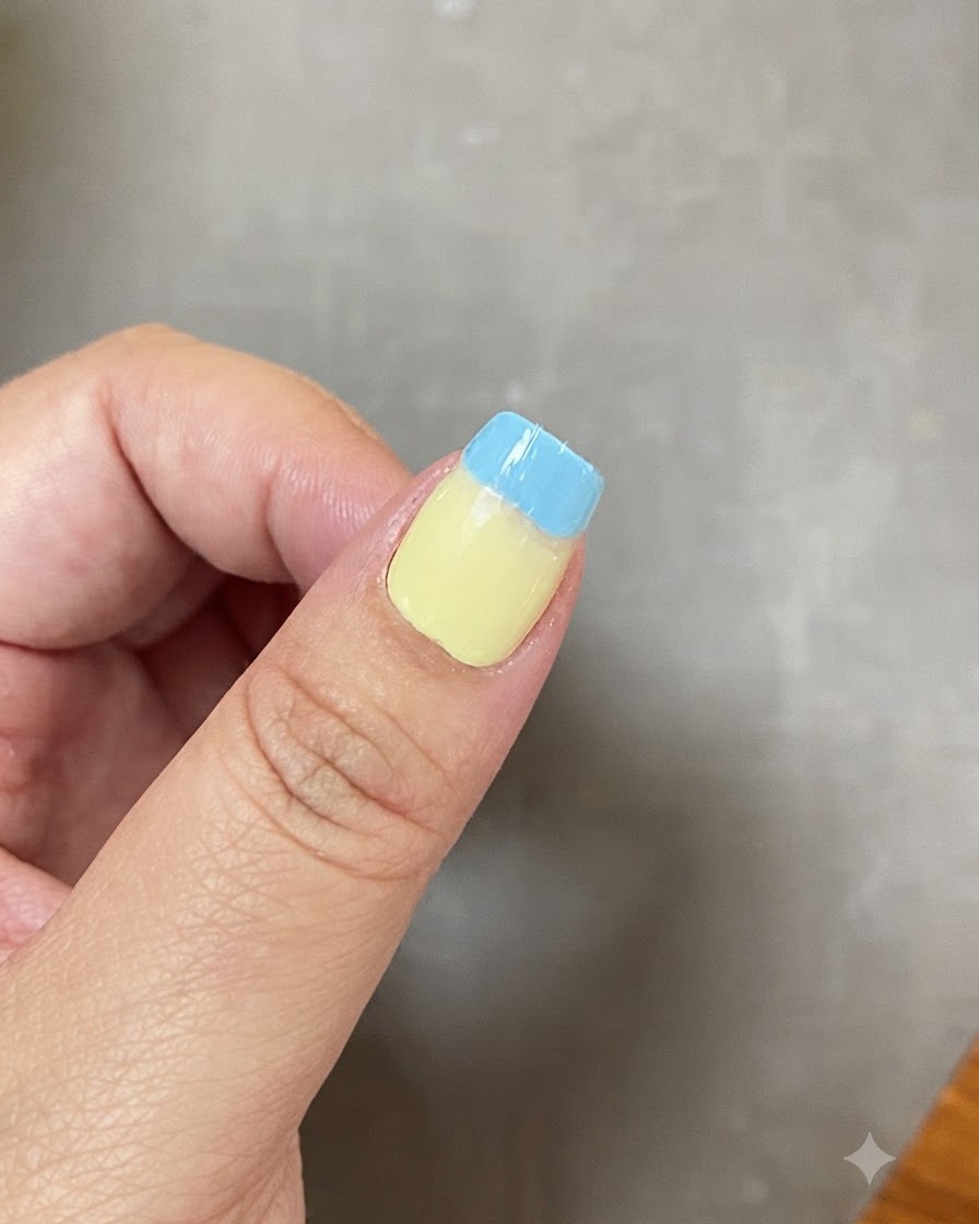 A fingernail showing a blended gradient transition between light green and light blue.