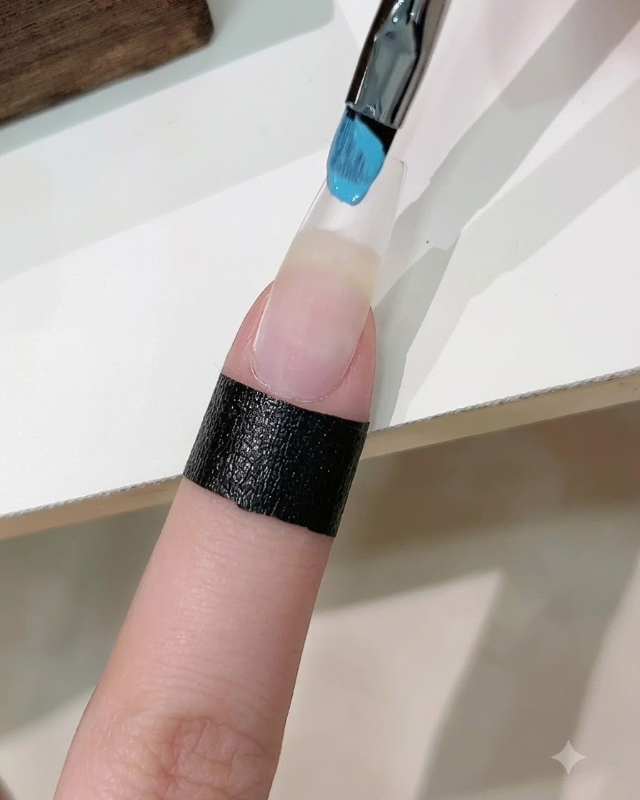 A sponge dabber loaded with blue and white gel polish dabbing a gradient onto an extended artificial nail.