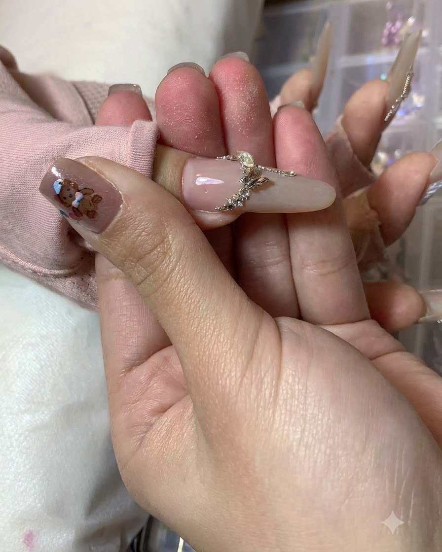 A nail artist adding final white accent strokes along the outer edges of the completed butterfly nail art.