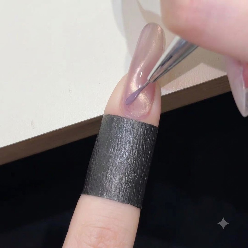 A fine liner brush painting a delicate squiggly line of purple gel polish over the shimmering pink cat-eye base.
