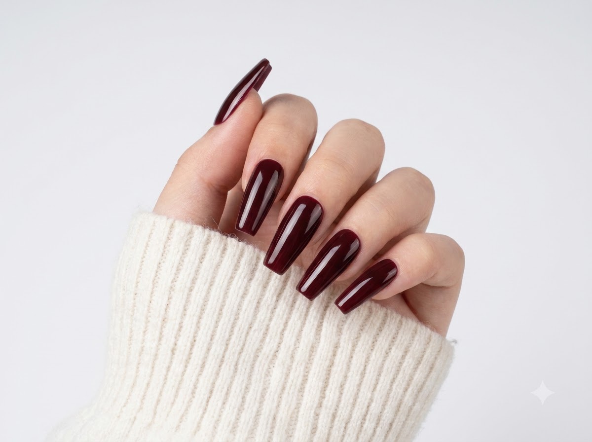 Fingers spread out displaying sheer nude bases and deep burgundy tips with a glossy finish.