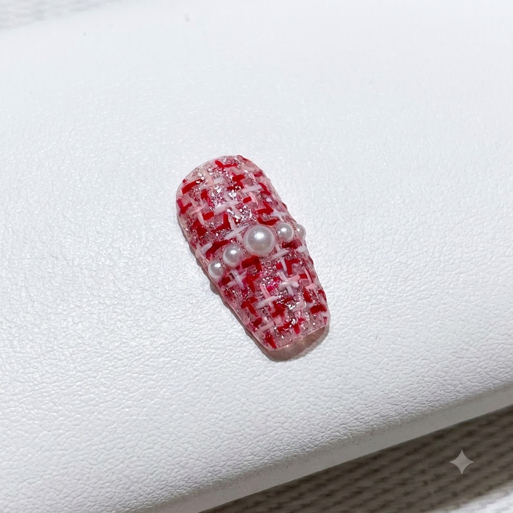 A fine brush filling in vibrant red gel polish on one side of a V-shaped French manicure tip.