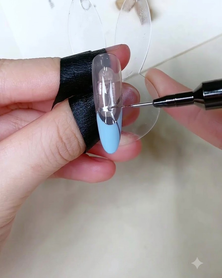 A precision tool applying tiny dots of clear adhesive gel onto the silver line of a French manicure design.