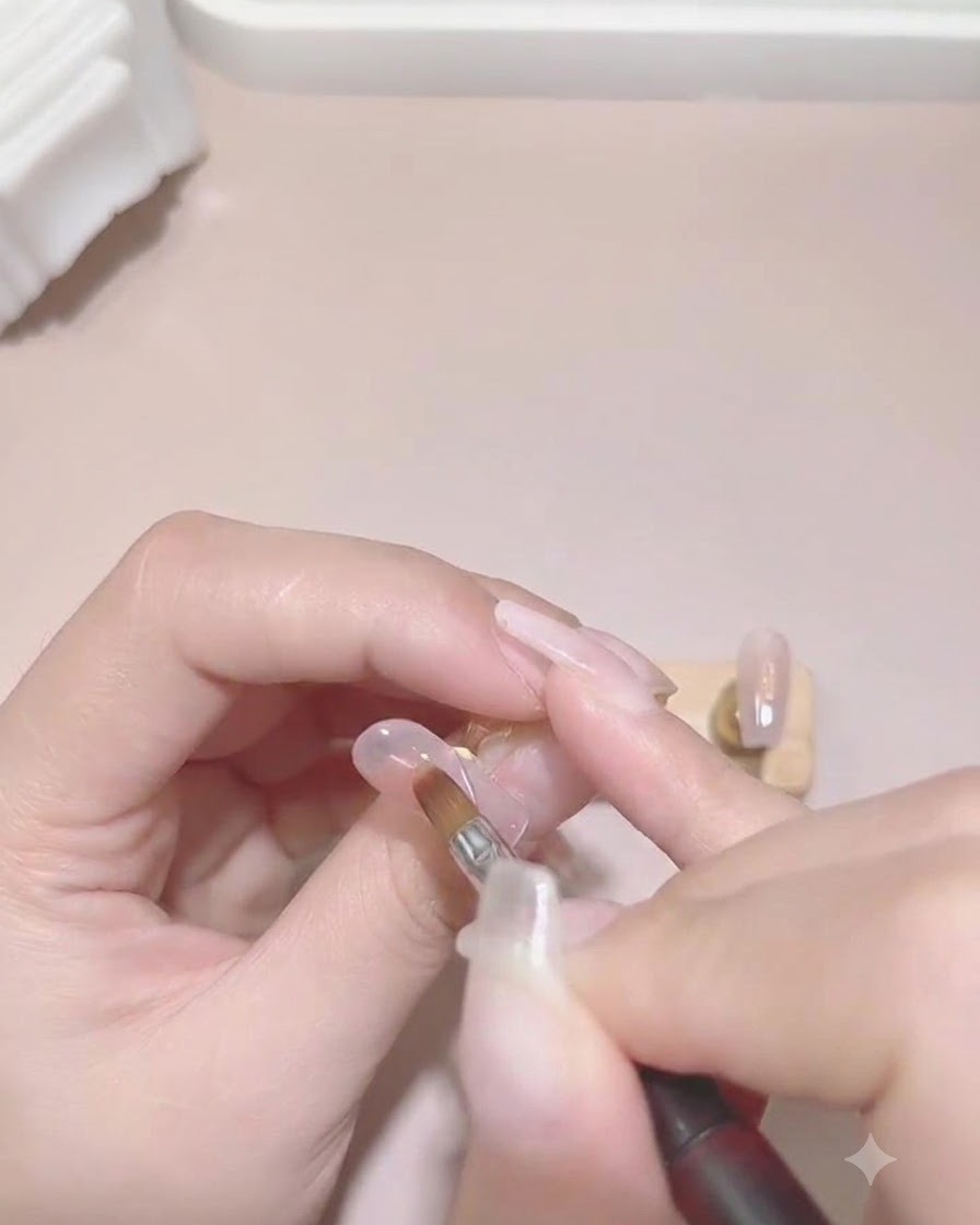 A hand placed inside a white UV/LED nail lamp curing the gel color layers.