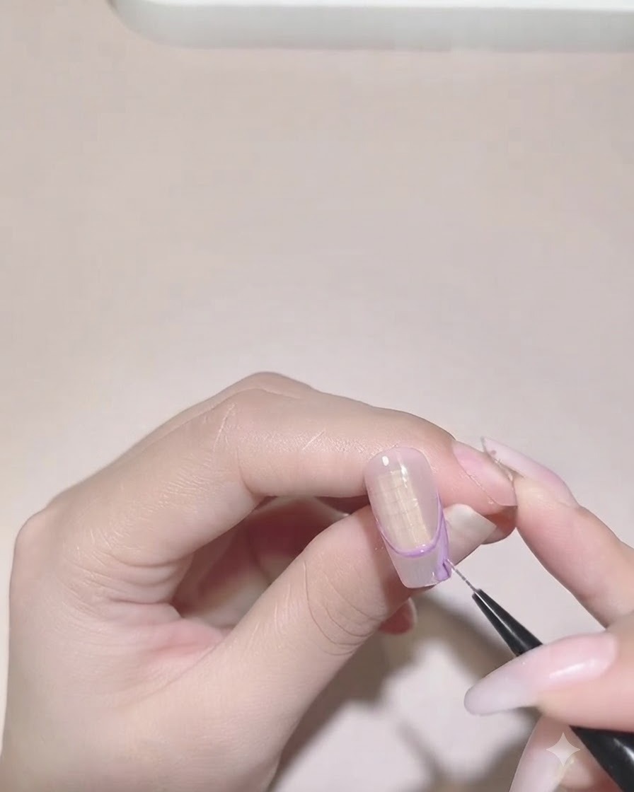 A detail brush filling in the purple color inside the irregular French tip boundary on a nail.