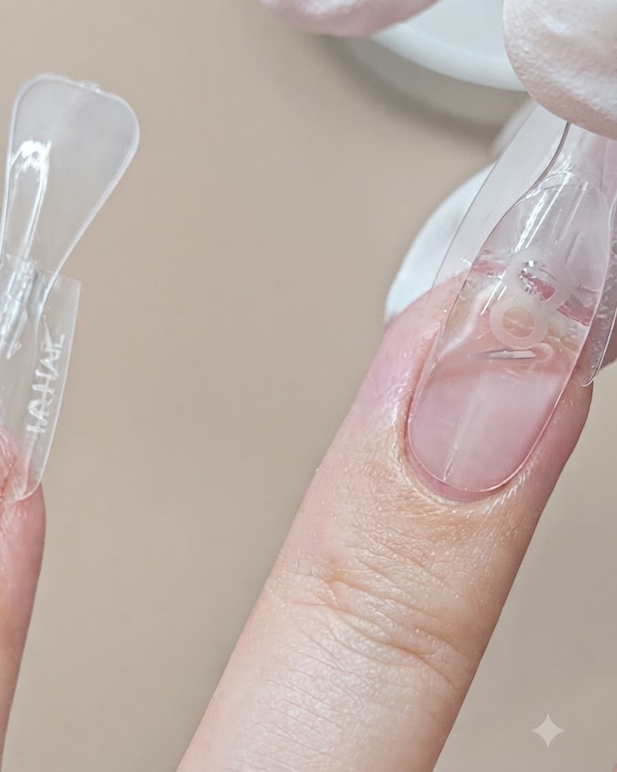 A dual form mold being applied to a middle fingernail next to another completed finger.