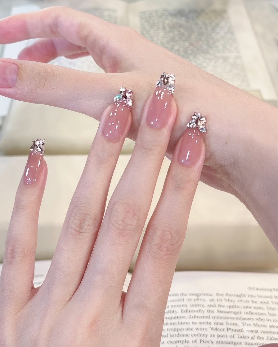 A smooth panning view across four manicured fingers showcasing a glossy light pink translucent gel surface.