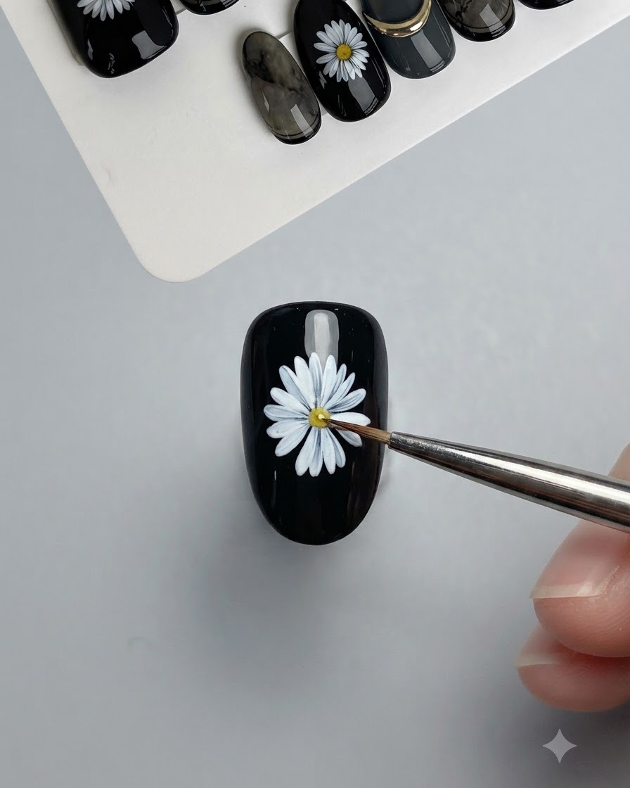 A fine lining brush detailing and sharpening the contours of the painted white daisy petals.