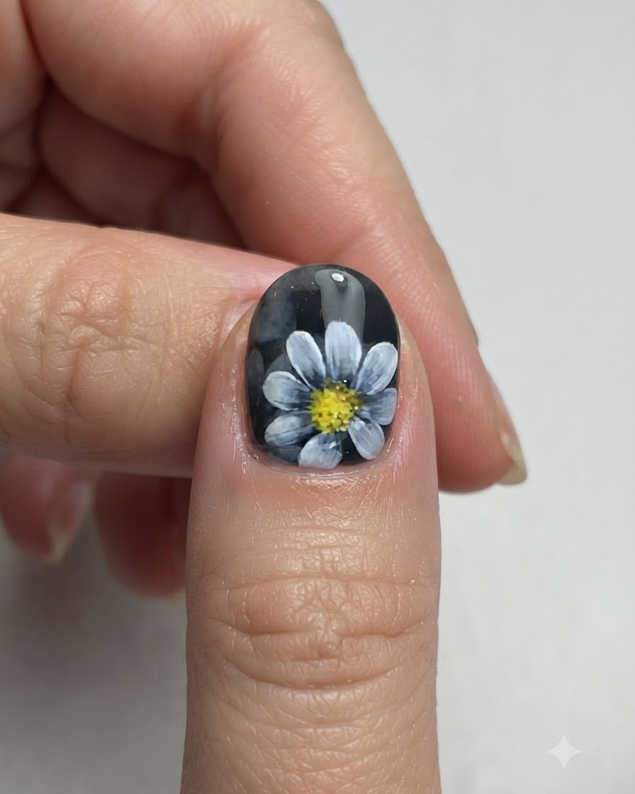 A close-up view of a finished Nordic style daisy nail art design ready for top coat.