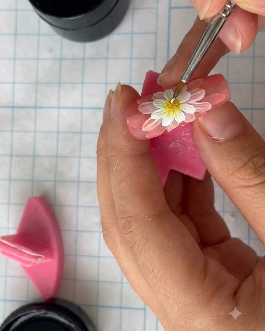 A hand holding a painted nail close to a curing lamp to set the gel.