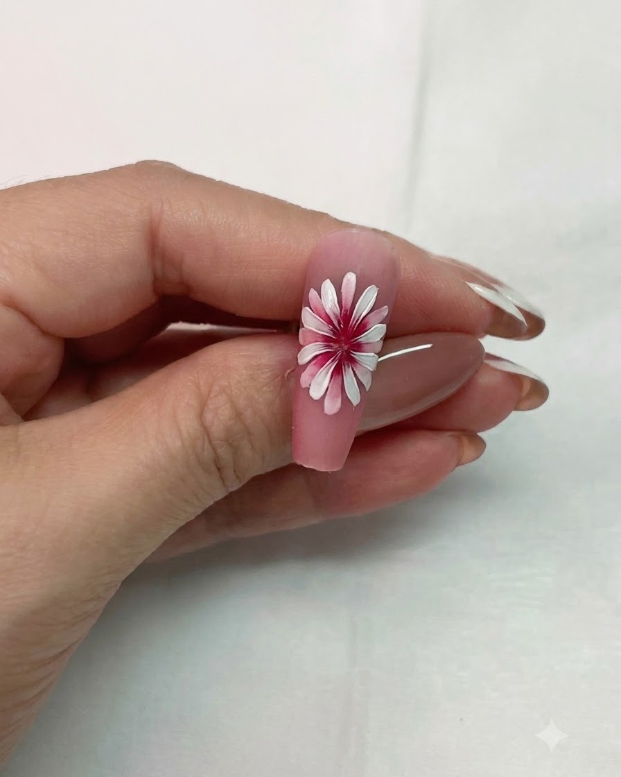 A completed double layer white daisy nail art design held up to show the dimensional 3D effect.