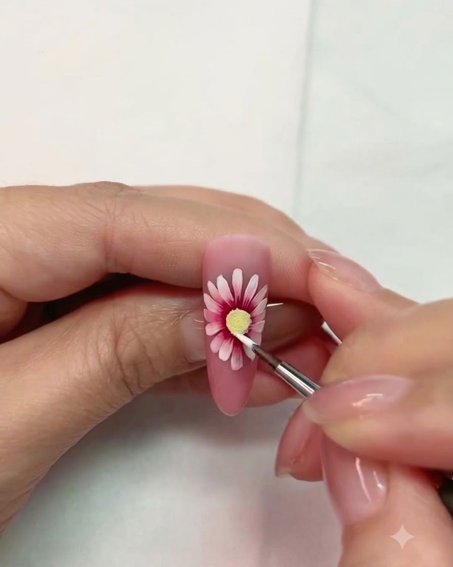 A close-up of a decorated nail being cured under an LED lamp.