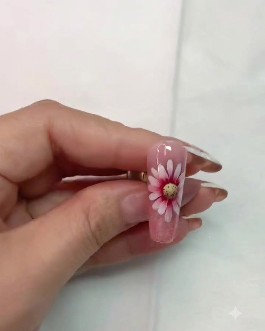 A fine liner brush carefully outlining and refining the details around the daisy flower center.