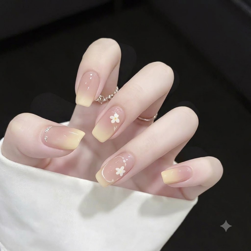 Close-up of square nails featuring yellow gradient tips, fine white French outline accents, and small polka dots.