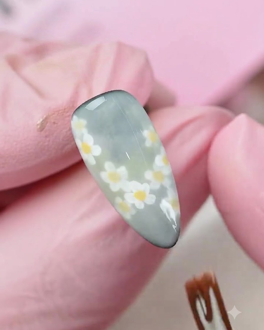 A sponge applicator dabbing a subtle gradient color onto a matte-finished decorated nail.