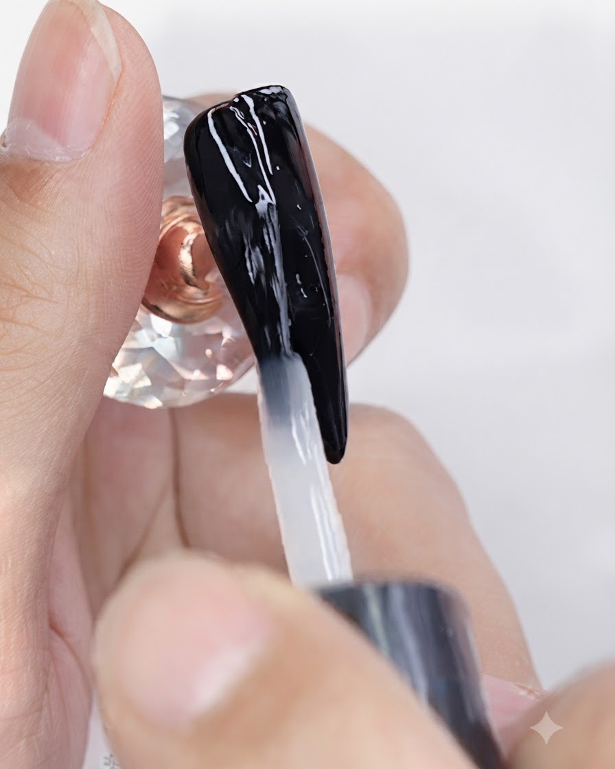 A brush applying clear matte top coat gel over a black gel-polished nail.