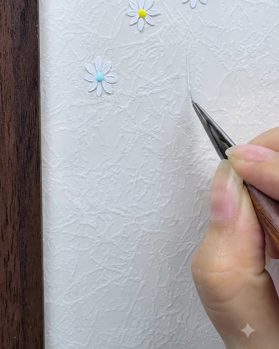 A fine liner brush drawing a thin white star-shaped intersecting grid on a textured surface.