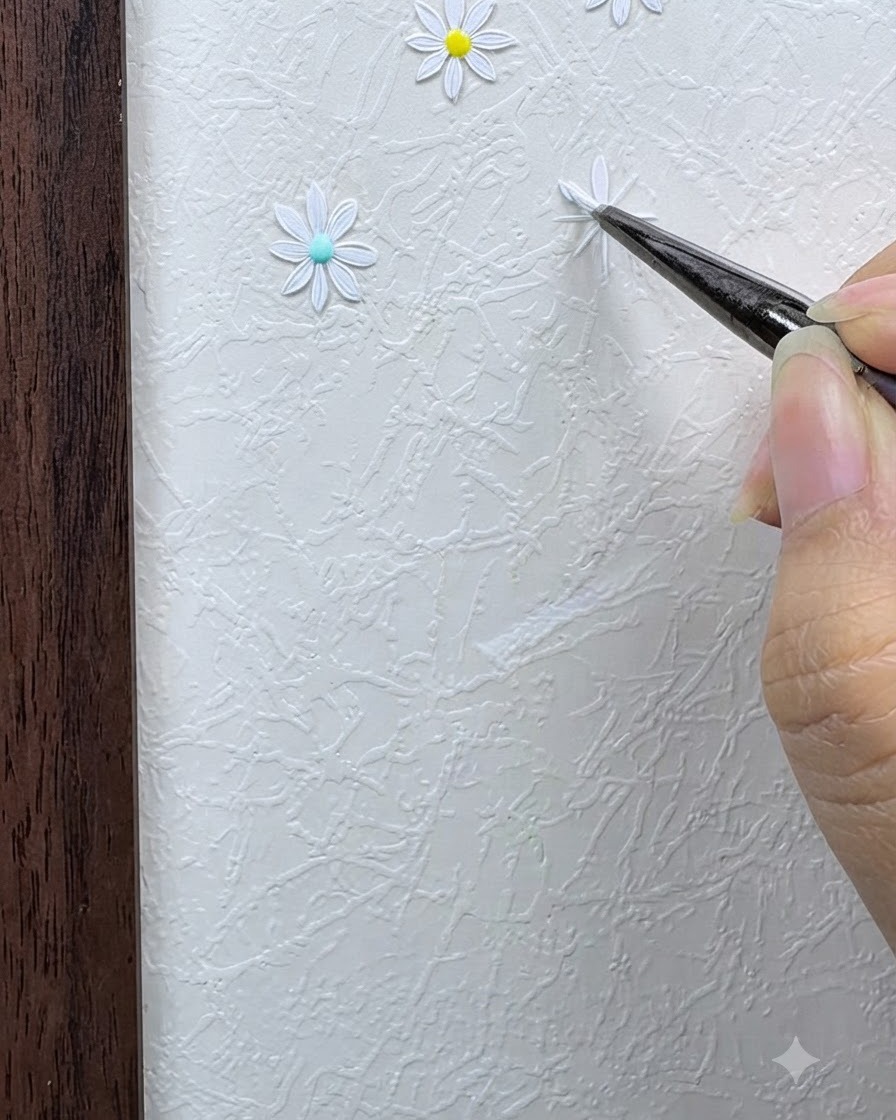 A fine brush applying the first white daisy petal using a dot-and-press stroke on the grid.