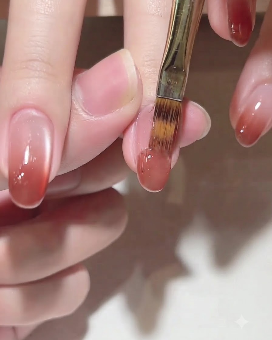 A brush applying color gel C102 onto the tip of the nail for a gradient effect.